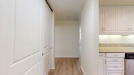 Located at 13999 Marquesas Way in the desirable Marina del Rey neighborhood of Los Angeles, this single-floor residence offers a well-designed layout with one bedroom and three bathrooms. Light wood-style flooring flows consistently throughout the space, creating a clean and cohesive aesthetic. The open living area is anchored by a fireplace and benefits from abundant natural light through large windows dressed with vertical blinds, with sliding glass doors leading to a private balcony that overlooks mature trees and the surrounding neighborhood. The galley-style kitchen is well-appointed with white shaker cabinetry, granite countertops, stainless steel appliances including a range, microwave, refrigerator, and dishwasher, and recessed lighting overhead. An adjacent dining area features a large window with a garden view and track lighting above. The generously sized primary bedroom offers corner windows that flood the room with natural light. The bathrooms are finished with white cabinetry, granite vanity countertops, and sliding glass-enclosed tub and shower combinations. The private balcony, accessible via sliding glass door, provides an outdoor retreat with a modern metal railing and peaceful tree-lined views.