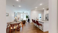 Located at 2300 N Friendship Rd in Sherman, TX, this thoughtfully designed one-bedroom, one-bathroom residence offers a cohesive open-concept layout that seamlessly connects the kitchen, dining, and living areas. The kitchen is a standout feature, boasting a large granite-topped island with seating for multiple bar stools, a two-tone cabinetry design pairing white upper cabinets with warm wood lower cabinets, stainless steel appliances, and under-cabinet lighting. Hardwood-style flooring flows throughout the main living areas, adding warmth and continuity. The living room benefits from large windows that invite abundant natural light, complemented by a ceiling fan for year-round comfort. The bedroom is a serene retreat, featuring a ceiling fan, a generous window with blinds, and a walk-in closet equipped with dual hanging rods and built-in shelving for ample storage. The bathroom offers a dual-sink vanity with granite countertops, framed mirrors, white cabinetry with brushed nickel hardware, and a full shower-tub combination. Clean white walls and recessed lighting throughout the space contribute to a bright, modern ambiance that is both functional and inviting.