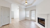 Located at 12100 W 136th St in Overland Park, Kansas, this single-story home offers a clean, modern aesthetic carried throughout its thoughtfully designed interior. The living area serves as a central highlight, featuring a tray ceiling accented with crown molding and a ceiling fan, light wood-look flooring, and a white-mantled fireplace positioned in the corner. A door provides direct access to the outdoors, and blinds-fitted windows allow for controlled natural light. Architectural details such as decorative columns and arched openings connect the living space to adjoining areas, adding structural character throughout.

The kitchen is well-appointed with two-tone cabinetry — white upper cabinets paired with gray lower cabinets — complemented by white quartz countertops, a gray subway tile backsplash, stainless steel appliances, and a deep undermount sink. Light wood-look flooring continues here, maintaining a cohesive feel. The bedrooms feature neutral carpet and windows that bring in natural light, offering a comfortable and quiet atmosphere. A bathroom includes a tiled tub-shower combination with light wood-look flooring. A dedicated laundry area with overhead shelving and in-unit washer and dryer adds everyday convenience. Throughout, the home presents a bright, neutral palette with consistent finishes.