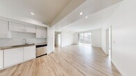 Located at 744 Hartford Ave in Los Angeles, CA, this contemporary 2-bedroom, 2-bathroom residence offers a thoughtfully designed single-level layout with a clean, modern aesthetic throughout. Light wood-style flooring runs continuously across the entire space, complemented by crisp white walls and recessed lighting that create a bright, airy atmosphere.

The open-concept kitchen and living area serves as the heart of the home. The kitchen is well-appointed with white shaker cabinetry, a subway tile backsplash, stone-toned countertops, and a full suite of stainless steel appliances including a refrigerator, gas range, built-in microwave, and dishwasher. The expansive living area flows naturally from the kitchen and opens to a private balcony through sliding glass doors, bringing in abundant natural light and urban views of the surrounding Los Angeles cityscape.

A wide hallway connects the living spaces to the two bedrooms. The primary bedroom is generously sized, featuring a large mirrored sliding-door closet and ample natural light. The second bedroom also includes a window with city views. Both bathrooms offer tub-shower combinations with sliding glass enclosures and light wood-toned flooring, maintaining the home's cohesive modern design. A dedicated closet provides additional storage, rounding out this well-organized and stylish residence.