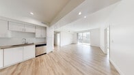 Located at 744 Hartford Ave in Los Angeles, CA, this contemporary 2-bedroom, 2-bathroom residence offers a thoughtfully designed single-level layout with a clean, modern aesthetic throughout. Light wood-style flooring runs continuously across the entire space, complemented by crisp white walls and recessed lighting that create a bright, airy atmosphere.

The open-concept kitchen and living area serves as the heart of the home. The kitchen is well-appointed with white shaker cabinetry, a subway tile backsplash, stone-toned countertops, and a full suite of stainless steel appliances including a refrigerator, gas range, built-in microwave, and dishwasher. The expansive living area flows naturally from the kitchen and opens to a private balcony through sliding glass doors, bringing in abundant natural light and urban views of the surrounding Los Angeles cityscape.

A wide hallway connects the living spaces to the two bedrooms. The primary bedroom is generously sized, featuring a large mirrored sliding-door closet and ample natural light. The second bedroom also includes a window with city views. Both bathrooms offer tub-shower combinations with sliding glass enclosures and light wood-toned flooring, maintaining the home's cohesive modern design. A dedicated closet provides additional storage, rounding out this well-organized and stylish residence.