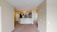 Located at 1210 Seventh Ave S in Sartell, Minnesota, this single-floor residence offers a thoughtfully designed layout with a warm, neutral color palette throughout. The open-concept kitchen is a standout feature, boasting rich dark wood cabinetry, dark granite-style countertops, stainless steel appliances including a refrigerator, electric range, and built-in microwave, and a peninsula with pendant lighting that creates an inviting breakfast bar. Tile flooring anchors the kitchen, while plush carpeting extends throughout the living and bedroom areas. The spacious living and dining areas are filled with natural light from large windows adorned with vertical blinds, and a ceiling fan adds comfort and airflow. The dining area features an elegant pendant light fixture. Bedrooms are generously sized with carpeted floors, natural light from blinds-fitted windows, baseboard heating, and ample closet space with sliding doors. The bathrooms are cleanly finished with tile flooring, a wide vanity with a single-basin sink, a large mirror with overhead lighting, and a walk-in shower stall. The overall ambiance is functional and comfortable, making this a practical and pleasant living space in a residential Sartell neighborhood.
