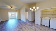 Located at 1703 Island Home Ave in Knoxville, TN, this well-appointed 3-bedroom, 2-bathroom single-story home offers a functional and comfortable layout. The open living and dining area features durable hardwood-style flooring, a ceiling fan, and an elegant chandelier, with natural light flowing in through large windows. The kitchen is thoughtfully designed with rich dark wood cabinetry, granite countertops, and a full suite of stainless steel appliances including a range, microwave, dishwasher, and refrigerator, all set atop matching hardwood-style floors. The bedrooms offer plush carpeting, ceiling fans, and ample natural light from well-placed windows with outdoor views. The primary bedroom includes a walk-in closet with built-in wire shelving. Additional closet storage is also available throughout the home. Both bathrooms are finished with granite-topped vanities and hardwood-style flooring, with one featuring a tiled tub-shower combo. A dedicated laundry room houses a full-sized washer and dryer with overhead wire shelving. The hallway connects all rooms efficiently, contributing to a cohesive and practical floor plan throughout this move-in-ready Knoxville home.