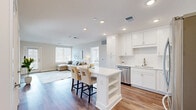 Located at 4301 Old William Penn Highway in Pittsburgh, PA, this well-appointed 2-bedroom, 2-bathroom residence offers a thoughtfully designed single-level layout with a clean, modern aesthetic throughout. The open-concept living and kitchen area serves as the heart of the home, anchored by a bright white kitchen featuring tall shaker-style cabinetry, a subway tile backsplash, stainless steel appliances, and a central island with bar seating — ideal for both everyday dining and entertaining. Warm hardwood-style flooring flows through the main living areas, complementing the recessed lighting and neutral color palette. The living room opens to a covered outdoor balcony with black iron railings, wood-beam ceilings, and open views of the surrounding Pittsburgh landscape. The spacious primary bedroom features plush carpeting, large windows that invite natural light, and access to a generous walk-in closet with wire shelving. A second well-sized bedroom and two full bathrooms — including one with classic black-and-white mosaic tile flooring and a soaking tub — complete the layout. Two closets provide ample storage throughout the residence, making this a functional and stylish home in a convenient Pittsburgh location.