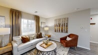 Located at 4048 Battleground Ave in Greensboro, NC, this well-appointed one-bedroom, one-bathroom residence offers a thoughtfully designed single-floor layout that maximizes every square foot. The entryway welcomes you with wood-look flooring and neutral gray walls that carry seamlessly throughout the main living areas, creating a cohesive and calming aesthetic.

The open-concept living, dining, and kitchen area serves as the heart of the home. The living room features a bright window dressed with elegant gold drapes, flooding the space with natural light. The kitchen is equipped with stainless steel appliances, including a full-size refrigerator, and is complemented by white cabinetry and a casual dining area nearby.

A hallway connects the main living space to the private bedroom, which is carpeted for comfort and offers a generous closet for storage. The full bathroom features a tub-shower combination with wood-look flooring that ties into the rest of the home's design language.

A dedicated laundry area with a full-size washer and dryer adds a practical convenience rarely found at this scale. Clean lines, soft neutral palettes, and consistent finishes throughout give this residence a modern yet inviting character ideal for comfortable everyday living.