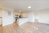 Located at 72 South Essex Avenue in Orange, NJ, this thoughtfully designed 2-bedroom, 2-bathroom residence offers a clean, modern aesthetic across a well-organized single-floor layout. The open-concept living, dining, and kitchen area serves as the heart of the home, anchored by a peninsula with dark countertops that provides both prep space and a casual dining option. The kitchen is fully equipped with stainless steel appliances—including a gas range, over-the-range microwave, and refrigerator—complemented by light wood cabinetry, a subway tile backsplash, and a undermount sink. Light wood-tone flooring runs seamlessly throughout the space, enhancing the bright, airy atmosphere created by the crisp white walls and recessed lighting. The generously sized primary bedroom features large black-framed windows that invite abundant natural light and offer elevated views of the surrounding neighborhood. The second bedroom is equally well-lit with its own set of wide windows overlooking the tree-lined cityscape. Both bathrooms are finished with large-format neutral tile surrounds and soaking tubs with shower fixtures and wood-toned vanities. The unit also includes four closets with wire shelving systems, a dedicated laundry area, and a utility room, providing exceptional storage and everyday convenience.