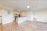 Located at 72 South Essex Avenue in Orange, NJ, this thoughtfully designed 2-bedroom, 2-bathroom residence offers a clean, modern aesthetic across a well-organized single-floor layout. The open-concept living, dining, and kitchen area serves as the heart of the home, anchored by a peninsula with dark countertops that provides both prep space and a casual dining option. The kitchen is fully equipped with stainless steel appliances—including a gas range, over-the-range microwave, and refrigerator—complemented by light wood cabinetry, a subway tile backsplash, and a undermount sink. Light wood-tone flooring runs seamlessly throughout the space, enhancing the bright, airy atmosphere created by the crisp white walls and recessed lighting. The generously sized primary bedroom features large black-framed windows that invite abundant natural light and offer elevated views of the surrounding neighborhood. The second bedroom is equally well-lit with its own set of wide windows overlooking the tree-lined cityscape. Both bathrooms are finished with large-format neutral tile surrounds and soaking tubs with shower fixtures and wood-toned vanities. The unit also includes four closets with wire shelving systems, a dedicated laundry area, and a utility room, providing exceptional storage and everyday convenience.