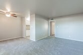 This single-floor unit offers a well-organized layout designed for comfortable everyday living. The spacious living area is finished with wall-to-wall carpeting and neutral-toned walls, creating a clean and versatile canvas. A ceiling fan overhead provides added comfort, while the open sightline to the kitchen gives the space an airy, connected feel. A sliding glass door floods the living area with natural light and opens directly onto a private, fenced outdoor patio, extending the living space outdoors.

The kitchen features white cabinetry, a granite-style countertop, and tile flooring, providing a functional and tidy cooking area that flows seamlessly from the main living space. Two well-proportioned bedrooms are each carpeted and painted in soft, neutral tones. Both rooms include windows fitted with vertical blinds that allow for natural light and privacy control.

The bathroom is finished with tile flooring and includes a full-size tub and shower combo with white tile surround, a vanity with a stone-style countertop and sink, and a mirrored medicine cabinet. Clean lines and understated finishes throughout the unit lend a consistent, move-in-ready character to the entire space.