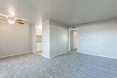 This single-floor unit offers a well-organized layout designed for comfortable everyday living. The spacious living area is finished with wall-to-wall carpeting and neutral-toned walls, creating a clean and versatile canvas. A ceiling fan overhead provides added comfort, while the open sightline to the kitchen gives the space an airy, connected feel. A sliding glass door floods the living area with natural light and opens directly onto a private, fenced outdoor patio, extending the living space outdoors.

The kitchen features white cabinetry, a granite-style countertop, and tile flooring, providing a functional and tidy cooking area that flows seamlessly from the main living space. Two well-proportioned bedrooms are each carpeted and painted in soft, neutral tones. Both rooms include windows fitted with vertical blinds that allow for natural light and privacy control.

The bathroom is finished with tile flooring and includes a full-size tub and shower combo with white tile surround, a vanity with a stone-style countertop and sink, and a mirrored medicine cabinet. Clean lines and understated finishes throughout the unit lend a consistent, move-in-ready character to the entire space.