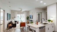 Located at 900 E Six Forks Rd in Raleigh, NC, this thoughtfully designed 2-bedroom, 3-bathroom residence offers a comfortable and modern living experience across a single floor. The open-concept layout seamlessly connects the kitchen, dining area, and living room, creating a bright and cohesive communal space. Wood-style flooring runs throughout the main living areas, complementing the neutral color palette.

The kitchen is equipped with stainless steel appliances, white shaker-style cabinetry, light countertops, and a decorative tile backsplash. A kitchen island provides additional prep space and flows naturally into the dining area, which features recessed lighting and easy access to the entry. The living room is anchored by a ceiling fan and large sliding glass doors that open to an outdoor area, filling the space with natural light.

Both bedrooms are carpeted and well-lit by large windows with outdoor views. The spacious primary bedroom includes a walk-in closet with built-in shelving. The bathrooms are finished with wood-style flooring, white vanities, and tub-shower combinations. A dedicated laundry area and hallway closet add practical functionality. Overall, the residence offers a clean, contemporary aesthetic with a warm and inviting ambiance.