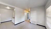 Located at 580 Oakhaven Circle in Immokalee, Florida, this single-floor residence offers three bedrooms, one bathroom, a kitchen, a hallway, and a closet within a compact and efficiently designed floor plan. The interior features a clean, neutral palette of white walls and light-colored carpeting throughout the bedrooms, accented by bold dark baseboards that provide a crisp visual contrast. The primary bedroom is a well-proportioned space, benefiting from natural light through a window with blinds and includes an open closet with a hanging rod for storage. The two additional bedrooms are straightforward, carpeted rooms with ample wall space and easy access to the hallway. The kitchen is a galley-style space with white cabinetry, granite-look countertops, a stainless steel sink, and white appliances including a range and refrigerator, with tile-style flooring providing a practical surface. The full bathroom features a tub-shower combination, a vanity with white cabinetry, and tile flooring, maintaining the home's consistent, clean aesthetic. A dedicated closet and hallway add organizational utility to the layout. Overall, the residence presents a functional and straightforward living environment suitable for everyday comfort.