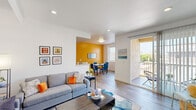 This well-appointed single-floor residence offers five bedrooms and three bathrooms, delivering generous accommodation across a thoughtfully designed layout. The open-concept living and dining area serves as the heart of the home, featuring light hardwood-style flooring, recessed lighting, and a bold mustard yellow accent wall that energizes the dining space. A sliding glass door leads directly to a private balcony, bringing in natural light and outdoor views, while a large window in the dining area further brightens the space. The galley-style kitchen is finished with dark cabinetry, white countertops, a mosaic tile backsplash, and stainless steel appliances including a gas range, microwave, and dishwasher, providing a fully equipped cooking environment. The five bedrooms are bright and cleanly finished with white walls, hardwood-style flooring, and windows with outdoor views. The primary bedroom is a comfortable size and is served by a dedicated bathroom featuring a dual-sink vanity with marble-style countertops and white cabinetry. Additional bathrooms include tub-shower combinations with sliding glass enclosures and single vanities. A connecting hallway ties all rooms together efficiently, completing this spacious and colorfully accented residence.