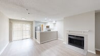 Located at 765 Polk Dr in Arlington, TX, this single-floor unit offers three bedrooms and one bathroom within a thoughtfully designed layout. The open-concept living and kitchen area serves as the heart of the home, anchored by a tile-surround fireplace with a classic white mantel and light wood-look flooring that flows throughout. Large windows invite natural light and provide pleasant outdoor views, creating a bright and welcoming atmosphere.

The kitchen is well-appointed with white shaker cabinetry, a subway tile backsplash, stainless steel appliances including a refrigerator, range, microwave, and dishwasher, and a peninsula with a double sink and light countertops — ideal for both cooking and casual dining. A skylight overhead adds additional natural illumination to the space.

Each of the three bedrooms features plush carpeting, neutral walls, and sliding closet doors for ample storage. The primary bedroom includes a built-in closet and a window seat bathed in natural light. Ceiling fans in select bedrooms add comfort year-round. The bathroom is finished with full-height ceramic tile surrounding a soaking tub and shower combination, complemented by wood-look flooring. A connecting hallway ties the layout together efficiently, making this a functional and comfortable home.