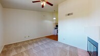 Located at 1777 W Orange Grove Rd in Tucson, Arizona, this single-floor residence offers a practical and well-organized layout designed for comfortable living. The living area is generously sized, featuring neutral carpet flooring, a ceiling fan with light fixture, and a large window dressed with vertical blinds that allows natural light to fill the space. A welcoming entryway with a front door and adjacent window provides a bright first impression upon entry.

The open-concept design connects the living and dining areas to the kitchen, which is equipped with light wood cabinetry, a white refrigerator, electric range with over-the-range microwave, dishwasher, and a sink. Warm hardwood-style flooring runs throughout the kitchen and dining area, complementing the cabinetry tones. Notably high vaulted ceilings in this zone enhance the sense of openness. A built-in fireplace adds a cozy focal point to the main living space, and a tall storage cabinet provides additional organization.

The bedroom is carpeted and includes a dedicated closet with a hanging rod, offering ample storage. The bathroom features a full-size soaking tub and shower combination with chrome fixtures, a wood-toned vanity, and hardwood-style flooring, creating a clean and functional space throughout.