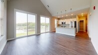 Located at 482–498 Westport St in Norfolk, VA, this single-floor unit showcases a thoughtfully designed open-concept layout with a seamless flow between the living and kitchen areas. The living room stands out with dramatic vaulted ceilings and large sliding glass doors that flood the space with natural light and provide access to a balcony with outdoor views of the surrounding landscape.

The kitchen is well-appointed with crisp white shaker-style cabinetry, light granite countertops, a central island, stainless steel appliances including a range, microwave, and refrigerator, and warm wood-look flooring that continues throughout the main living areas.

The bedrooms are carpeted for comfort and feature neutral tones, generous closet space, and windows that bring in natural light. Tray ceiling detailing adds architectural interest to select bedrooms.

Two bathrooms serve the unit: a full bathroom with a spacious single-sink vanity featuring white cabinetry, a large mirror, and a walk-in glass-enclosed shower with built-in shelving; and a half bathroom with a matching vanity and wood-look flooring. Both bathrooms carry a clean, contemporary aesthetic consistent with the rest of the unit. The overall design is modern and move-in ready, reflecting a cohesive neutral palette throughout.