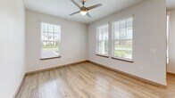 Located in Vero Beach, FL, this thoughtfully designed one-bedroom, one-bathroom home offers a bright and modern living experience on a single floor. The open-concept main area seamlessly connects the living room, dining area, and kitchen, creating a cohesive and functional space bathed in natural light from large, blinds-fitted windows. Light-toned wood-look flooring runs throughout the main living areas, complementing the clean, neutral color palette.

The kitchen is a standout feature, equipped with stainless steel appliances including a French door refrigerator, electric range, and built-in microwave. White shaker-style upper cabinets contrast beautifully with warm wood-toned lower cabinets, while a central island with a quartz countertop and undermount sink provides additional prep space and seating. Pendant lighting above the island adds a polished finishing touch. A dedicated pantry offers generous storage.

The bedroom is a comfortable retreat featuring plush carpeting, a ceiling fan, and multiple windows that invite abundant natural light and views of the surrounding neighborhood. A closet provides ample storage within the room.

The bathroom is well-appointed with a full tub-shower combination featuring tile surround, a wood-toned vanity cabinet, and wood-look flooring. The overall design aesthetic throughout is clean, contemporary, and move-in ready.