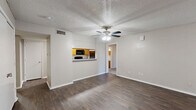 This single-floor, 2-bedroom, 2-bathroom residence offers a practical and comfortable layout across a thoughtfully organized floor plan. The living room serves as the heart of the home, featuring rich dark hardwood-style flooring, a textured ceiling, a ceiling fan with light fixture, and a charming brick-hearth fireplace with a classic mantle — an inviting focal point for the space. Large sliding glass doors allow natural light to filter in, enhancing the open and airy feel of the room.

The kitchen is efficiently designed with warm honey-toned cabinetry, light countertops, and a full suite of black appliances including a refrigerator, electric range, and over-the-range microwave. A pass-through window connects the kitchen to the living area, adding a sense of openness. A dedicated pantry provides additional storage convenience.

Both bedrooms are carpeted for comfort and include ceiling fans with lighting. The primary bedroom is generously sized with ample closet access. The second bedroom also offers comfortable proportions and direct sightlines to the kitchen area.

The two bathrooms are finished with warm wood cabinetry, light stone-toned countertops, and full tub-shower combinations with clean white tile surrounds. Additional highlights include four closets for storage, an in-unit laundry room, and a connecting hallway that ties all areas together seamlessly.