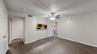 This single-floor, 2-bedroom, 2-bathroom residence offers a practical and comfortable layout across a thoughtfully organized floor plan. The living room serves as the heart of the home, featuring rich dark hardwood-style flooring, a textured ceiling, a ceiling fan with light fixture, and a charming brick-hearth fireplace with a classic mantle — an inviting focal point for the space. Large sliding glass doors allow natural light to filter in, enhancing the open and airy feel of the room.

The kitchen is efficiently designed with warm honey-toned cabinetry, light countertops, and a full suite of black appliances including a refrigerator, electric range, and over-the-range microwave. A pass-through window connects the kitchen to the living area, adding a sense of openness. A dedicated pantry provides additional storage convenience.

Both bedrooms are carpeted for comfort and include ceiling fans with lighting. The primary bedroom is generously sized with ample closet access. The second bedroom also offers comfortable proportions and direct sightlines to the kitchen area.

The two bathrooms are finished with warm wood cabinetry, light stone-toned countertops, and full tub-shower combinations with clean white tile surrounds. Additional highlights include four closets for storage, an in-unit laundry room, and a connecting hallway that ties all areas together seamlessly.