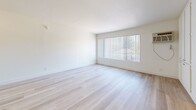 Located at 15343 Vanowen Ave in Van Nuys, Los Angeles, this single-floor unit offers a thoughtfully organized layout that makes efficient use of its compact footprint. The interior is finished with light wood flooring throughout, contributing to a bright and cohesive aesthetic across all areas.

The combined kitchen and living room serves as the heart of the unit. The kitchen features white cabinetry — both upper and lower — with granite-look laminate countertops and a stainless steel sink. A pass-through counter connects the kitchen to the open living area, enhancing the sense of space. The living area is anchored by a large, full-width window dressed with vertical blinds, allowing generous natural light to flood the room and creating an airy, open atmosphere.

The unit includes two bathrooms. One bathroom features a clean, all-white tub and shower surround alongside a toilet. The second bathroom is equipped with a wide vanity topped with a granite-look countertop, an integrated oval sink, white cabinetry with drawers below, and a mirror above. Both bathrooms maintain a clean, neutral palette consistent with the rest of the unit.

Overall, the space presents a clean, minimalist interior with white walls, natural light, and warm wood-toned flooring, offering a functional and comfortable living environment in the Van Nuys neighborhood of Los Angeles.