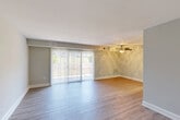 Located at 3404 Hewitt Ave in Silver Spring, MD, this single-floor residence offers two bedrooms and two bathrooms with a practical, well-organized layout. The combined living and dining area is the heart of the home, featuring neutral-toned carpet, a ceiling fan with light fixture, and a large sliding glass door dressed with vertical blinds that fills the space with natural light and provides outdoor views. The spacious feel of this area makes it ideal for both relaxing and entertaining. The kitchen is equipped with light wood cabinetry offering generous storage, speckled countertops, a stainless steel sink, and black appliances including a gas range, built-in microwave, and dishwasher, all set on durable wood-look flooring. The primary bedroom is a generously sized retreat featuring carpeted floors, a bright window with outdoor views, and multiple closet doors for ample storage. The second bedroom also offers comfortable proportions with carpeted floors and closet access. The bathrooms feature wood-toned vanities, white countertops, and light wood-look flooring for easy maintenance. With six closets distributed throughout, storage is abundant. The unit's neutral color palette and clean finishes create a bright, move-in-ready atmosphere.