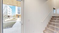 Located at 2130 S 18th Ave in Bozeman, Montana, this contemporary multi-level townhome spans three floors and offers a thoughtfully designed layout with 2 bedrooms, 3 bathrooms, and 2 closets. The ground floor features an attached garage with an automatic opener, providing direct interior access via a raised entry with storage closet, along with utility connections and an electrical panel. A glass-paneled front door with views of the surrounding community welcomes you into the entry level, where a staircase leads up to the main living floor. The main floor showcases an open-concept kitchen and living area finished with light wood laminate flooring, recessed lighting, and white subway tile backsplash. The kitchen features light wood cabinetry, quartz countertops, a center island with an undermount sink, and stainless steel appliances, complemented by a stylish barn-style sliding door. The top floor houses two spacious bedrooms filled with natural light from large windows offering neighborhood views. The generously sized primary bedroom includes a walk-in closet with built-in wire shelving. The primary bathroom impresses with a dual-sink vanity, light wood cabinetry, quartz countertops, and a well-lit mirror. Clean white walls and wood-tone finishes carry a cohesive, modern aesthetic throughout the entire home.