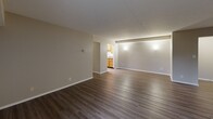 Located at 32450 Cromwell Dr. in Solon, OH, this single-floor, three-bedroom, two-bathroom home offers a well-organized and functional layout. The expansive living room is a standout feature, showcasing dark hardwood-style flooring, a textured ceiling, and a sliding glass door that opens directly onto a private balcony with outdoor views. Adjacent to the living room, the combined dining and kitchen area is efficiently designed with warm oak cabinetry, granite-style countertops, and black appliances including a gas range, microwave, and refrigerator, all set above durable wood-look flooring. The three bedrooms are comfortably sized, with the generously proportioned primary bedroom offering direct access to a private bathroom. All bedrooms feature plush carpeting and closet storage, with four closets distributed throughout the home. The two bathrooms are clean and practical, each equipped with a tub-shower combination, with one featuring a vanity with granite-style countertops and wood-look flooring. A dedicated utility room, entrance foyer, and hallway round out the thoughtfully planned floor plan, creating a cohesive and comfortable living environment.