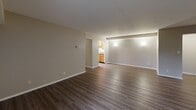 Located at 32450 Cromwell Dr. in Solon, OH, this single-floor, three-bedroom, two-bathroom home offers a well-organized and functional layout. The expansive living room is a standout feature, showcasing dark hardwood-style flooring, a textured ceiling, and a sliding glass door that opens directly onto a private balcony with outdoor views. Adjacent to the living room, the combined dining and kitchen area is efficiently designed with warm oak cabinetry, granite-style countertops, and black appliances including a gas range, microwave, and refrigerator, all set above durable wood-look flooring. The three bedrooms are comfortably sized, with the generously proportioned primary bedroom offering direct access to a private bathroom. All bedrooms feature plush carpeting and closet storage, with four closets distributed throughout the home. The two bathrooms are clean and practical, each equipped with a tub-shower combination, with one featuring a vanity with granite-style countertops and wood-look flooring. A dedicated utility room, entrance foyer, and hallway round out the thoughtfully planned floor plan, creating a cohesive and comfortable living environment.