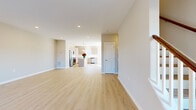 This three-floor home presents a clean, contemporary design characterized by light hardwood flooring, neutral warm-toned walls, and white trim throughout. The open-concept main living area flows seamlessly into the kitchen, which serves as a functional centerpiece of the home. The kitchen is equipped with stainless steel appliances, light taupe shaker-style cabinetry, a white quartz countertop island, subway tile backsplash, and pendant lighting with brass accents — combining style with practicality. Recessed lighting illuminates the space efficiently throughout.

The bedrooms are generously proportioned, offering ample natural light through well-placed windows. One bedroom includes a walk-in closet outfitted with wire shelving systems and built-in storage panels, providing organized storage. The bathrooms are finished with large-format marble-look tile, featuring both a soaking tub with a tiled surround and a separate glass-enclosed shower with chrome hardware and integrated corner shelving. A wood-toned vanity complements the bathroom's polished aesthetic. Throughout all three floors, the consistent use of light hardwood flooring, recessed lighting, and a neutral color palette creates a cohesive, modern ambiance.