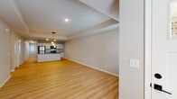 This single-floor home offers a thoughtfully designed open-concept layout that seamlessly connects the living, dining, and kitchen areas. Light-toned luxury vinyl plank flooring runs throughout the main living spaces, lending warmth and continuity, while recessed lighting and stylish pendant fixtures illuminate the interior with a clean, modern feel.

The kitchen is a standout feature, showcasing crisp white cabinetry with gold-toned hardware, dark granite countertops, a classic subway tile backsplash, and stainless steel appliances. A central island provides additional prep space and a natural gathering point within the open floor plan.

The living and dining areas are generously proportioned, benefiting from natural light streaming through windows fitted with horizontal blinds. A tray ceiling detail adds architectural interest overhead.

The bedrooms are carpeted for comfort and feature multiple windows that allow for ample natural light, creating bright and airy retreats. The bathrooms are well-equipped, with one offering a full soaking tub and shower surround, and another featuring a standalone shower with dark-framed glass doors and a vanity with granite countertops and gold hardware. Tile flooring in the bathrooms provides a clean, polished finish. Overall, the space presents a fresh, move-in-ready aesthetic with consistent, modern finishes throughout.