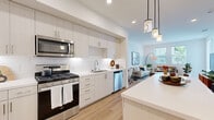 Located at 1445 Town Center Dr in Chula Vista, CA, this 2-bedroom, 1-bathroom residence offers a thoughtfully designed open-concept layout with clean, contemporary finishes throughout. Light wood-style flooring flows through the main living areas, complemented by bright white walls and recessed lighting that enhance the sense of openness.

The kitchen is a standout feature, showcasing tall white shaker-style cabinetry, white quartz countertops, a classic subway tile backsplash, and a full suite of stainless steel appliances including a gas range, microwave, and dishwasher. A central island with pendant lighting adds both functionality and style, while an in-unit washer and dryer are conveniently tucked nearby.

The open living room benefits from large windows that invite abundant natural light and provide outdoor views, creating a bright and welcoming atmosphere. Both bedrooms feature plush carpet flooring and ceiling fans, with the primary bedroom offering direct access to a private balcony through sliding glass doors. A walk-in closet connects seamlessly to the shared bathroom, which features white cabinetry, quartz countertops, and a large vanity mirror. The balcony provides a comfortable outdoor retreat, completing this well-rounded residence.