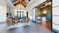 Located at 3374–3378 Provine Blvd in Gallatin, Tennessee, this generously sized single-story community clubhouse delivers a well-appointed blend of social, recreational, and functional spaces across a thoughtfully designed floor plan.

The living area serves as the architectural centerpiece, distinguished by soaring ceilings adorned with bold exposed wood beam detailing and wide-plank hardwood flooring. A statement chandelier anchors the room, while large windows flood the space with natural light and provide views of the surrounding community. Sage-green accent walls add warmth and depth to the bright, neutral palette.

Adjacent to the living area, a game room offers pool and shuffleboard tables beneath another chandelier, with floor-to-ceiling windows maintaining the space's light-filled character. Rich hardwood floors continue throughout, reinforcing the cohesive design aesthetic.

The dining room features a live-edge wood conference table beneath a modern linear pendant light, complemented by textured area rugs and private rooms accessible through glass-paneled doors — ideal for meetings or focused work sessions.

A dedicated office area showcases the same elevated design language, with coffered ceilings, sage-green wainscoting, and oversized windows framing outdoor views. The entry foyer features dramatic vaulted ceilings with wood detailing, large-format tile flooring, and sliding barn-style glass doors connecting to adjacent spaces.