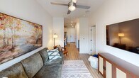 Located at 1750 S Osage Spring Dr in Rogers, Arkansas, this 1-bedroom, 1-bathroom unit offers a smartly organized floor plan that maximizes every square foot of its compact footprint. Light-toned luxury vinyl plank flooring runs throughout the main living areas, creating a cohesive and clean aesthetic.

The galley-style kitchen is well-equipped with stainless steel appliances, including a range, microwave, and dishwasher, complemented by white upper cabinetry, gray lower cabinets, white quartz countertops, and a classic subway tile backsplash. Recessed lighting illuminates the space efficiently.

The open living room connects seamlessly to the kitchen corridor, featuring a ceiling fan with light, a large window allowing natural light to fill the room, and warm neutral tones throughout.

The bedroom offers plush carpeting, a ceiling fan, and a window with natural light. It provides comfortable proportions with easy access to the bathroom and laundry area.

The bathroom includes a glass-enclosed walk-in shower with white subway tile, wood-look flooring, and a modern vanity with clean lines.

A dedicated laundry room houses a full-size stacked washer and dryer, adding significant everyday convenience to this efficiently designed residence.