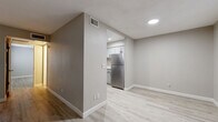 Located on East Baseline Road in Tempe, Arizona, this single-story one-bedroom, one-bathroom unit offers a thoughtfully designed layout with clean, modern finishes throughout. Light wood-look luxury vinyl flooring flows seamlessly across every room, complemented by neutral gray walls and crisp white baseboards, creating a bright and cohesive aesthetic.

The living room is an open, well-lit space featuring a sliding glass door with vertical blinds that opens to an outdoor area, allowing natural light to fill the room. A second entry point leads through a hallway directly into the main living area. The kitchen, accessible from the living space, is equipped with stainless steel appliances including a full-size refrigerator, white cabinetry, and recessed lighting overhead.

The generously sized bedroom includes a ceiling fan with light fixture, a window with horizontal blinds for natural light and privacy, and dual mirrored sliding-door closets providing ample storage. The bathroom is well-appointed with a full tub-shower combination, a white vanity with quartz-style countertop, brushed nickel hardware, and matching wood-look flooring that ties the space together. A connecting hallway links the rooms efficiently, completing this clean and functional single-floor layout.