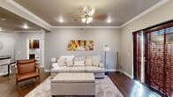 Located at 1726 E Second St in Little Rock, AR, this well-appointed 2-bedroom, 2-bathroom single-story home offers a thoughtfully designed layout with upscale finishes throughout. Rich hardwood flooring and elegant crown molding are consistent features across the living spaces, lending a polished, cohesive aesthetic.

The open-concept living room is warm and inviting, highlighted by a classic white marble fireplace, recessed lighting, and a ceiling fan. Large wood-shuttered glass doors allow natural light to fill the space. The kitchen is a standout, featuring rich dark wood cabinetry, dark granite countertops, a subway tile backsplash, stainless steel appliances, a kitchen island with bar seating, and track lighting overhead.

The spacious primary bedroom includes a ceiling fan, wood-shuttered windows, and direct access to a well-designed en-suite bathroom complete with dark wood cabinetry, granite countertops, and a soaking tub with tile surround. A dedicated closet with built-in shelving and cabinetry provides ample storage.

The second bedroom and additional bathroom maintain the same quality finishes found throughout. Neutral gray walls complement the warm wood tones, creating a sophisticated and comfortable atmosphere throughout this move-in-ready home.
