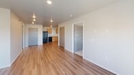 Located at 5340 W Vision Drive in Sioux Falls, South Dakota, Unit 311 is a thoughtfully designed single-floor residence that balances functionality with a clean, contemporary aesthetic. The open living area features warm hardwood-style flooring that flows seamlessly throughout the main living and kitchen spaces, creating a cohesive and inviting atmosphere. Recessed lighting and large windows allow natural light to fill the rooms, enhancing the bright, neutral color palette of the white walls and trim.

The kitchen is well-appointed with light maple cabinetry, white countertops, and a full suite of black appliances including a refrigerator, electric range, dishwasher, and microwave. A pendant light adds a subtle decorative touch above the workspace, and the open layout connects naturally to the living area.

Both bedrooms are carpeted for comfort and feature windows with blinds that bring in natural light while maintaining privacy. The unit includes two bathrooms — one with a walk-in shower and wood-toned tile flooring paired with a warm wood vanity, and a second with a full soaking tub and shower combination with tile-style flooring. A dedicated in-unit laundry area houses a full-size washer and dryer, adding practical convenience. The entryway includes a closet for additional storage.