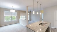 This thoughtfully designed 1-bedroom, 1-bathroom residence in Columbia, SC offers a comfortable and functional single-floor layout. The open-concept living and dining area flows seamlessly from the kitchen, creating a bright, connected space bathed in natural light from multiple windows with views of lush greenery. Plush carpeting runs throughout the living and bedroom areas, adding warmth underfoot.

The kitchen is a standout feature, showcasing granite countertops, a center island with a stainless steel undermount sink, dark espresso cabinetry reaching to the ceiling, a mosaic tile backsplash, and a full suite of stainless steel appliances including a refrigerator, range, and built-in microwave. Elegant pendant lighting illuminates the island and living area.

The generously sized bedroom offers dual windows with peaceful outdoor views, plush carpet, a ceiling fan, and convenient access to both a closet and the bathroom. The full bathroom is finished with granite countertops, dark cabinetry, tile flooring, and a tub/shower combination. A dedicated closet provides additional storage. The neutral color palette and consistent finishes throughout create a cohesive, move-in-ready environment.