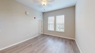 Located at 2775 Red Apple Circle in Kissimmee, Florida, this well-appointed one-bedroom, one-bathroom unit offers a thoughtfully designed layout across a single floor. The open-concept kitchen and living area serves as the heart of the home, bathed in natural light from windows fitted with horizontal blinds. The living area features light wood-style flooring and elevated ceilings with a ceiling fan, creating an airy and comfortable atmosphere.

The kitchen is outfitted with crisp white shaker-style cabinetry, granite-look countertops, a light blue tile backsplash, and a full suite of stainless steel appliances including a refrigerator, dishwasher, electric range, and over-the-range microwave. Track lighting overhead ensures the space is well-lit for cooking and entertaining.

The bedroom is a comfortable retreat featuring plush carpeting, generous closet space with double doors, a ceiling fan, and large windows that invite ample natural light. The adjoining full bathroom includes a tub-shower combination with classic white subway tile, a granite-top vanity, and wood-style flooring that complements the rest of the unit.

Throughout, neutral warm-gray walls and clean white trim create a cohesive, modern aesthetic that is both functional and inviting.