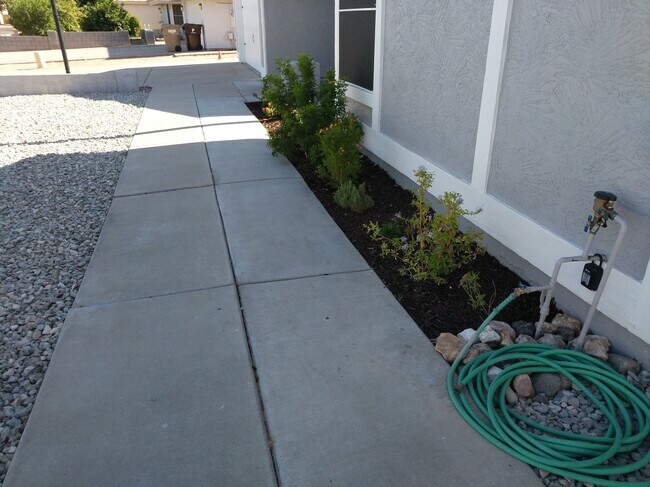 Front planter bed with mulch and hose bib with back-flow preventer. - 14101 N 78th Dr