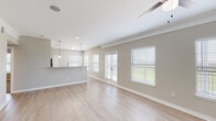 This well-appointed 2-bedroom, 2-bathroom residence in New Orleans, LA offers a thoughtfully designed single-floor layout that balances comfort and modern style. The open-concept living and dining area is bright and airy, featuring light hardwood-style flooring, crown molding, a ceiling fan, and multiple windows dressed with white blinds that invite abundant natural light. French doors provide additional outdoor views and ventilation, enhancing the welcoming ambiance. The kitchen is well-equipped with grey shaker-style cabinetry, granite countertops, a full suite of stainless steel appliances including a range, microwave, and refrigerator, a tile backsplash, and a built-in pantry with open shelving. Pendant lighting over the counter adds a polished finishing touch. Both bedrooms are generously sized, featuring ceiling fans and plush carpeting. The primary bath includes a granite-topped vanity and a glass-enclosed walk-in shower, while the second bath offers a granite vanity and a tiled soaking tub with shower. A spacious walk-in closet with wire shelving provides ample storage. A welcoming hallway connects the living spaces cohesively throughout the home.