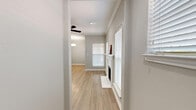 This well-appointed two-bedroom, two-bathroom single-floor residence in Dallas, Texas offers a thoughtfully designed layout with a clean, neutral aesthetic throughout. Light wood-style flooring flows seamlessly across the living areas, complemented by soft gray walls and crisp white trim and crown molding that add a polished touch.

The living room serves as a central gathering space, anchored by a white-mantled fireplace and bathed in natural light from multiple windows dressed with white plantation shutters and blinds. A ceiling fan overhead adds both comfort and style. Adjacent to the living room, the dining area features a modern pendant light fixture and direct access to the outdoors through a glass-paned door, further enhancing the natural light.

The kitchen is efficiently designed with white shaker cabinetry, a light quartz countertop, subway tile backsplash, stainless steel appliances, and a peninsula with bar seating — ideal for casual dining or entertaining.

The primary bedroom is generously sized with a ceiling fan and direct access to an en-suite bathroom featuring a dual-sink vanity with white cabinetry, a soaking tub, and a separate shower. Both bedrooms include dedicated closet space with built-in shelving. A dedicated laundry room with in-unit washer and dryer connections adds everyday convenience.
