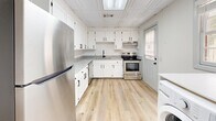 Located at 201 Pickens St in Clemson, SC, this two-story, 3-bedroom, 2-bathroom home is thoughtfully laid out across two floors. The main level features light wood-look flooring throughout, lending a clean, modern feel to the living and kitchen areas. The kitchen is a standout space, outfitted with white shaker-style cabinetry, black hardware accents, granite-look countertops, stainless steel appliances including a refrigerator and electric range, and a skylight panel that brings in additional overhead light. A washer unit is also conveniently located on this level. The staircase, carpeted in a warm brown tone, connects to the upper floor, where the three bedrooms are located. Each bedroom features plush carpeting, neutral wall tones, ceiling fans, and windows with blinds that allow for natural light. The spacious primary bedroom offers generous square footage with direct access to a bathroom. The bathrooms are finished in a crisp, modern style with white vanities, black matte fixtures, framed mirrors, and black hardware details. The full bath includes a tub-shower combination. Multiple bedrooms include closets with built-in shelving and hanging rods. Overall, the home presents a clean, updated aesthetic well-suited for comfortable living in Clemson.