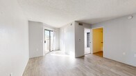 Located at 938 N Camino Seco in Tucson, Arizona, this single-floor, one-bedroom, one-bathroom unit offers a functional and well-organized layout. The living room is bright and open, featuring light wood-style flooring, neutral gray walls, a textured ceiling, and a sliding glass door that opens to a balcony, allowing natural light to fill the space. A ceiling fan is present, adding to the room's comfort. The galley-style kitchen is efficiently designed with white cabinetry, light countertops, a double sink, and white appliances including a refrigerator and electric range, all complemented by matching wood-style flooring. The bedroom is carpeted for warmth and comfort, featuring a window with blinds that brings in natural light and a closet for storage. A dedicated closet area is also accessible from the main living space. The bathroom is clean and bright, featuring a tiled tub-shower combination with multiple grab bars for accessibility, wood-style flooring, and a straightforward, practical layout. Throughout the unit, the light color palette and consistent finishes create a cohesive, easy-to-maintain living environment well-suited for Tucson's sunny climate.