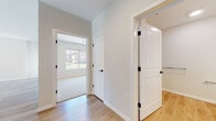 Located at 713 Bloomfield Ave in Bloomfield, Connecticut, this single-floor unit offers a clean, modern design with thoughtfully selected finishes throughout. The open-concept living and dining area is anchored by warm light hardwood flooring and neutral walls, creating a bright and welcoming atmosphere. A peninsula counter separates the living space from the kitchen, which is outfitted with dark cabinetry featuring matte black hardware, light countertops, and appliances including a range and microwave. A large window in the kitchen frames views of the surrounding greenery, flooding the space with natural light.

The hallway connects the living area to the private rooms, where the transition from hardwood to plush carpeting signals a quieter, more comfortable zone. The bedrooms are generously proportioned, featuring neutral tones and windows that invite natural light. One bedroom benefits from a bright outlook with scenic outdoor views. Stylish two-panel white doors with matte black hardware are consistent throughout the unit, lending a cohesive modern aesthetic.

The bathroom is well-appointed with light hardwood-style flooring, a white vanity with a large mirror, and accessibility features including grab bars. The overall design emphasizes clean lines, neutral palettes, and functional layouts, making this a polished and move-in ready space.