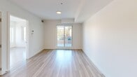 Located in the desirable Altadore neighbourhood of Calgary, this thoughtfully designed 2-bedroom, 3-bathroom unit offers a clean, contemporary aesthetic throughout. The open-concept kitchen and living area serves as the heart of the home, anchored by a generous waterfall-edge island with an undermount sink and pendant lighting overhead. The kitchen is equipped with stainless steel appliances, a gas range, a wall-mounted range hood, and two-toned cabinetry — white uppers paired with warm taupe lowers — complemented by a tiled backsplash and under-cabinet lighting. Light-toned engineered hardwood flooring runs continuously throughout, enhancing the bright, airy feel of the space. Both bedrooms are well-proportioned and bathed in natural light from large windows that frame views of the surrounding neighbourhood. The primary bedroom features sliding glass door access to an outdoor area. The three bathrooms are finished to a high standard: one includes a deep soaker tub set within striking marble-look porcelain tile surrounds, while another features a frameless glass walk-in shower with floor-to-ceiling marble-look tile, a rainfall showerhead, and an illuminated vanity mirror. Clean white walls and modern fixtures unify the overall design, creating a polished and cohesive living environment.