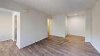 Located at 12215 Little Patuxent Parkway in Columbia, MD, this one-bedroom, one-bathroom residence offers a functional and well-organized single-floor layout. Wood-look plank flooring runs consistently throughout the home, lending a cohesive and clean aesthetic to every room.

The living room is bright and open, featuring a sliding glass door with vertical blinds that allows natural light to fill the space and provides access to an outdoor area with greenery views. An adjacent dining area connects smoothly to the galley-style kitchen, which is outfitted with warm wood cabinetry, granite countertops, a stainless steel sink, and stainless steel appliances including a refrigerator, dishwasher, and range.

The bedroom is a generously sized private retreat with a window offering natural light and views of the surrounding landscape, along with a closet for storage. The full bathroom features a tiled tub-shower combination, a toilet, and a vanity with wood-look flooring.

A dedicated laundry room houses a stacked washer and dryer unit along with a water heater and electrical panel, providing essential utilities in one convenient space. A hallway connects the rooms with additional closet storage. The overall design is neutral and move-in ready, emphasizing practicality and comfort throughout.