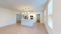 Located at 1125 Westwood Boulevard in Mt. Juliet, Tennessee, this well-designed one-bedroom, one-bathroom unit offers a thoughtfully arranged single-floor layout with a clean, modern aesthetic throughout. Light wood-style flooring flows seamlessly across every room, contributing to a bright and cohesive feel.

The open-concept kitchen and living area serves as the heart of the unit. The kitchen is outfitted with white shaker-style cabinetry, a classic white subway tile backsplash, stainless steel appliances including a refrigerator, electric range, and microwave, and a central island with a white countertop, undermount sink, and matte black fixtures. Stylish globe pendant lights hang above the island, adding a contemporary touch. Track lighting supplements the overhead illumination.

The living area is generously proportioned, offering an open and airy feel with natural light filtering through the windows. The bedroom is a comfortable size, featuring a ceiling fan, a window with natural light, and direct access to both the bathroom and a dedicated walk-in closet. The closet is equipped with wire shelving and hanging rods, maximizing storage. The bathroom features a tub-shower combination with matte black fixtures, a white vanity, and continued wood-style flooring. The unit's neutral palette and modern finishes create a clean, move-in-ready living environment.