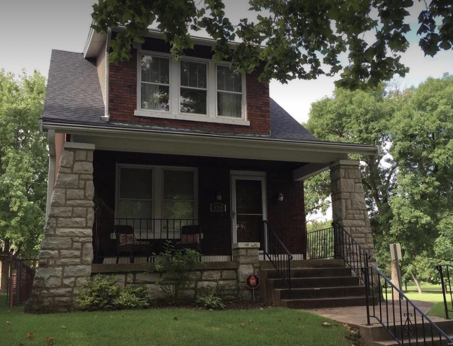 The home sits high above the tree-lined street. Enjoy the front porch in this park-like setting. - 4398 Holly Hills Blvd