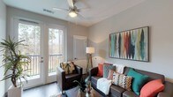Located at 10300 University Pkwy in Pensacola, Florida, this single-floor residential unit offers a thoughtfully designed layout with a range of functional and attractive living spaces. The open living and dining area serves as the heart of the unit, featuring wood-style flooring, a ceiling fan, a wall-mounted fireplace, and large glass doors that open onto a private balcony overlooking lush, wooded surroundings. Natural light flows freely through the expansive glazing, creating a bright and welcoming atmosphere throughout.

The kitchen is outfitted with stainless steel appliances, including a range, microwave, and refrigerator, complemented by granite-style countertops, two-tone cabinetry in white and warm wood tones, and track lighting overhead.

The bedrooms are comfortably sized, each featuring ceiling fans, wood-style flooring, and windows that invite natural light. One bedroom includes a dedicated desk area, making it well-suited for study or remote work.

The bathrooms are clean and modern, each equipped with a tub-shower combination, granite-topped vanity with wood cabinetry, recessed lighting, and wood-style flooring. The overall aesthetic throughout the unit is contemporary and cohesive, with neutral wall tones providing a versatile backdrop for a variety of décor styles.