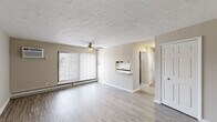 Located at 6503 Marsol Rd in Mayfield Heights, OH, this two-bedroom, two-bathroom unit offers a practical and well-appointed single-floor layout. The living room serves as the heart of the space, featuring durable luxury vinyl plank flooring, a textured ceiling with a ceiling fan, and a large window with vertical blinds that allows ample natural light to fill the room. A baseboard heating system runs along the perimeter, providing efficient warmth throughout. A pass-through opening connects the living room to the kitchen, which is equipped with a stainless steel refrigerator, upper cabinetry, and a sink — creating an open and functional flow between the two spaces. Both bedrooms are finished with plush wall-to-wall carpeting, neutral-toned walls, and vertical-blind windows that invite natural light. Each bedroom benefits from closet storage and direct access to one of the two bathrooms. The bathrooms are cleanly finished, featuring white vanities with mirrored medicine cabinets, and a tub-shower combination adorned with marble-style white tile surround. Soft, neutral tones are carried consistently throughout the unit, creating a cohesive and move-in-ready atmosphere.