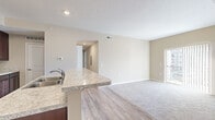 Located at 4100 Lakeview Crossing in Columbus, Ohio, this single-story home offers five bedrooms and two full bathrooms within a efficiently arranged floor plan. The combined kitchen and living area forms the heart of the home, where rich dark-cabinetry, light granite-style countertops, a kitchen island with a built-in sink, and black appliances define the culinary space. Wood-style flooring runs through the kitchen, transitioning to plush carpet in the spacious living room, which features a sliding glass door opening to a private balcony with neighborhood views.

The two hallways connect the bedrooms and bathrooms throughout the layout. The generously sized primary bedroom provides a comfortable retreat, complemented by a walk-in closet with wire shelving for organized storage. Additional bedrooms feature carpet flooring, neutral walls, and windows that bring in natural light. One bathroom includes a glass-enclosed walk-in shower with tile flooring, while the second bathroom offers a vanity with dark cabinetry, a granite-style countertop, and tile flooring. A dedicated closet provides additional storage. The home's warm, neutral color palette and consistent finishes create a cohesive, move-in-ready ambiance throughout.